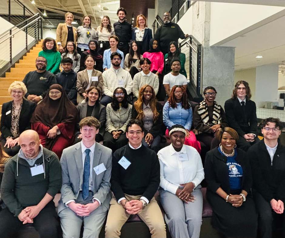 Students and Faculty, as well as Community Service/Meeting & Events Chair Chris Reynolds, and Chapter President Kyle Smith, sitting on a stairwell, smiling for a group photo